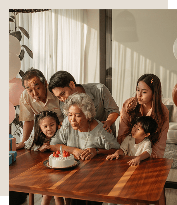 Family gathered around a birthday cake, celebrating together.
